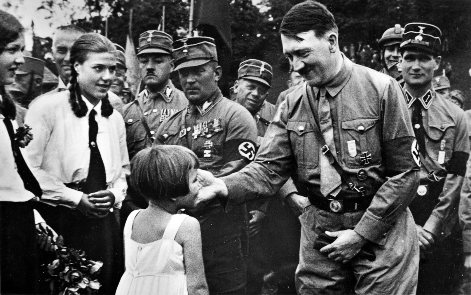 A little girl is offering Adolf Hitler a small bouquet during Gera's Gauparteitag